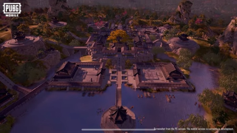 Bird's-eye view of a traditional East Asian-inspired settlement surrounded by water, featuring pagoda-style buildings, bridges, and lush greenery, from PUBG Mobile.